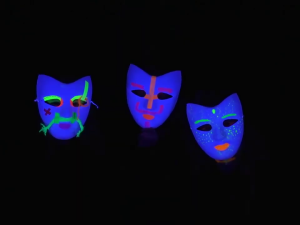 Drei blaue Masken im Schwarzlicht
